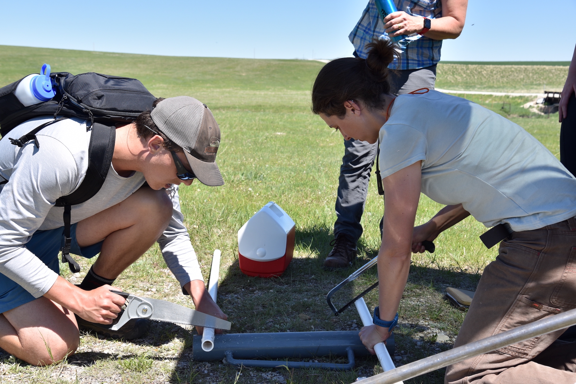 Skye Keeshin and Caitlin Mitchell saw screens into PVC pipes for the groundwater wells