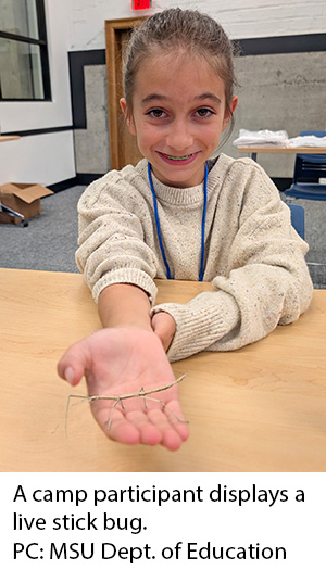 A camp participant displays a live stick bug. Photo credit: MSU Department of Education