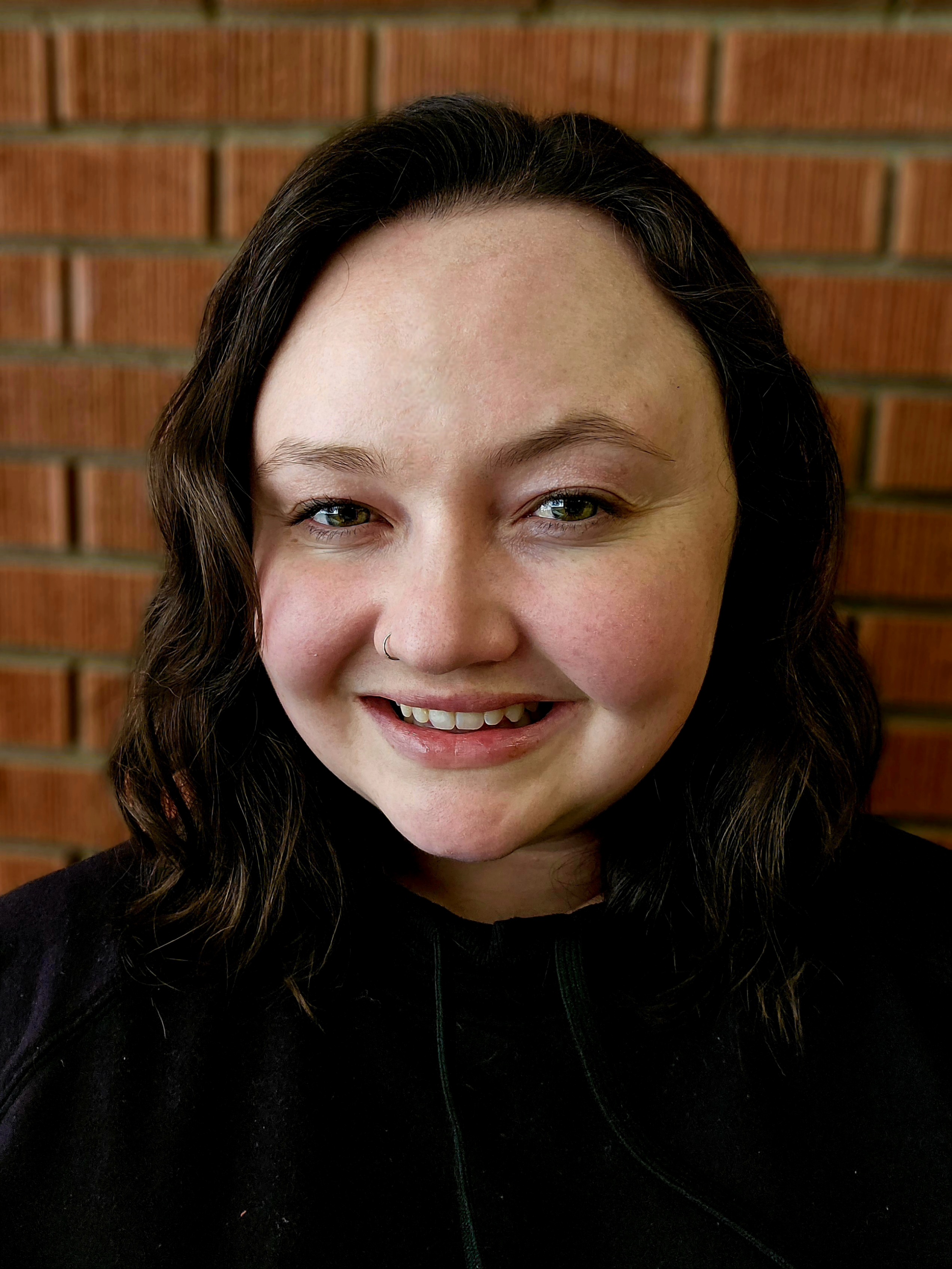 Head shot of Reilly Tunby with a brick background