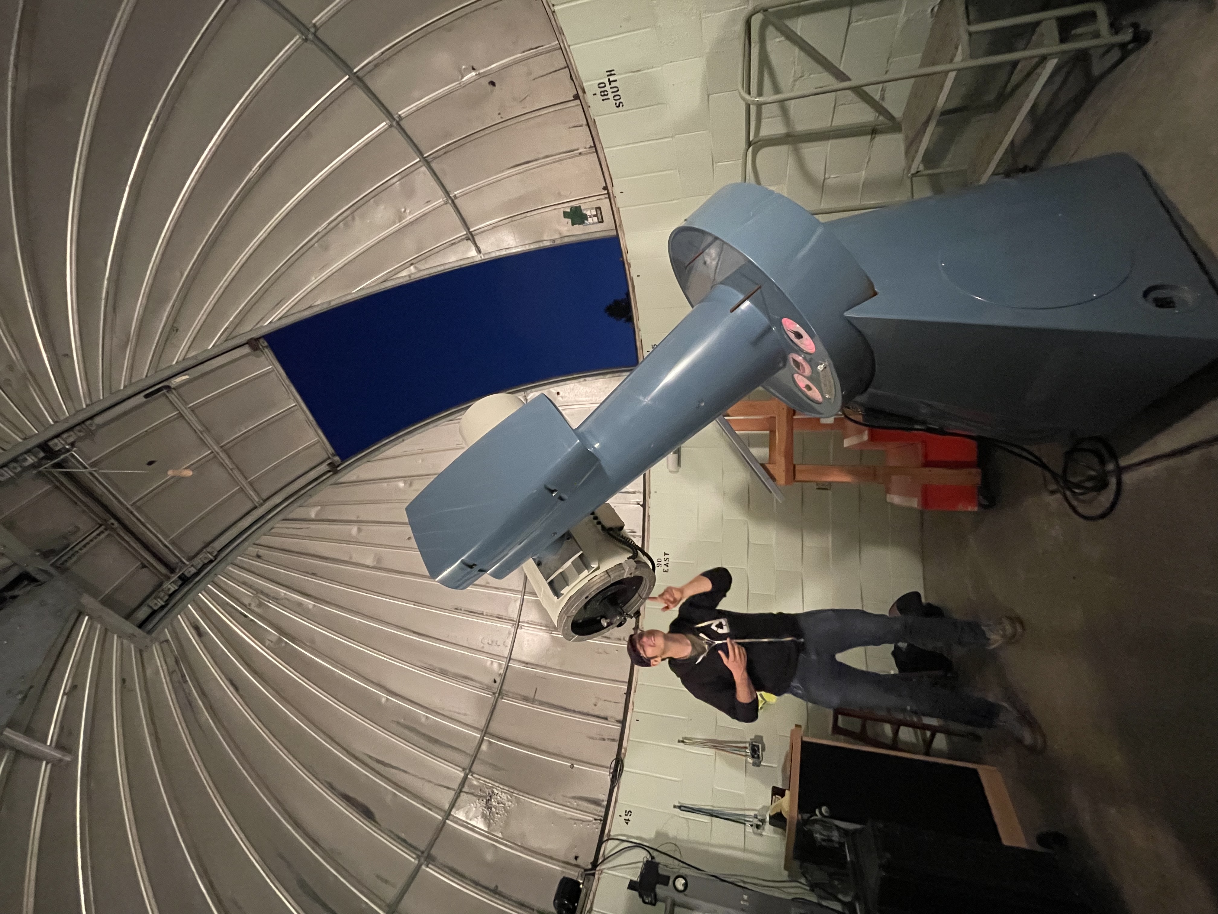 Photo of Nick Wethington with a large telescope