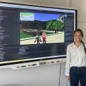 Graduate student Tasha Stryker stands next to a development version of the online Crash Course game