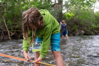 Peaks & Potentials camper studying stream flow. Photo by Brendan Kristiansen.
