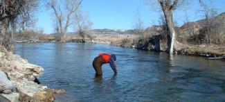 A volunteer takes a water sample on the Crow Indian Reservation. MSU photo.