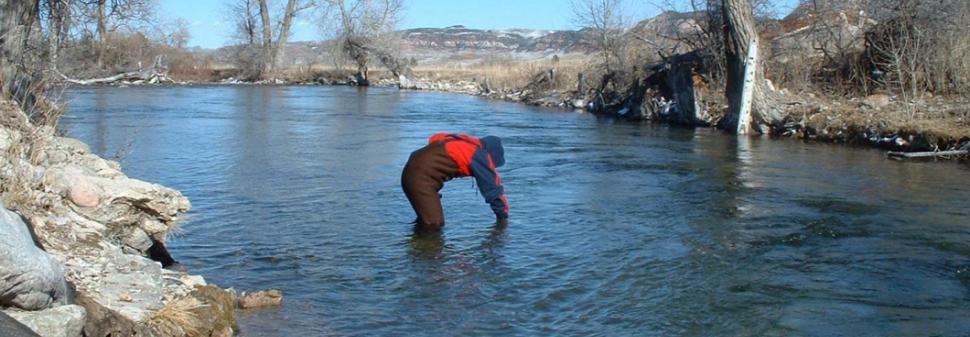 A volunteer takes a water sample on the Crow Reservation. MSU photo.