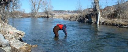 A volunteer takes a water sample on the Crow Reservation. MSU photo.