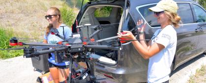 CREWS undergraduate students Maddie Torrey, left, and Shannon Hamp, right, begin the process of packing up the drone after a flight on the Upper Clark Fork River in July 2021.