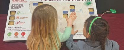 two young students interact with an air quality sonification exhibit