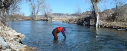 A volunteer takes a water sample on the Crow Indian Reservation. MSU photo.